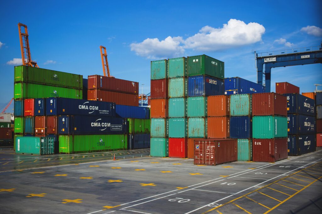 Stack of colorful shipping containers at a bustling seaport, symbolizing the importance of SBLC in global trade and finance, and how to identify genuine Standby Letters of Credit (SBLC) providers 